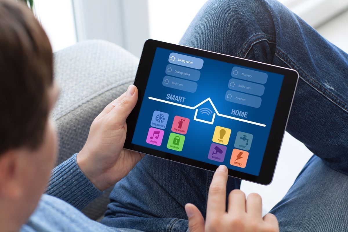 Person stellt Smart Home über ein Tablet ein